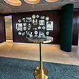 Brass cocktail table with blue marble top positioned in a stylish indoor venue with decorative wall art, timber panelling, and modern ceiling lighting