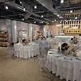 Modern wedding venue with round banquet tables, clear Victorian chairs, floral arrangements and decorative lighting throughout the reception space