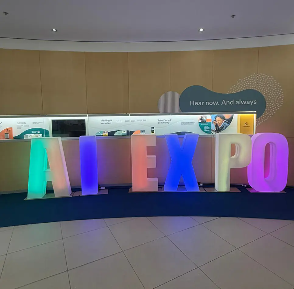 Colour changing illuminated AI EXPO letters displayed inside a corporate exhibition and conference venue