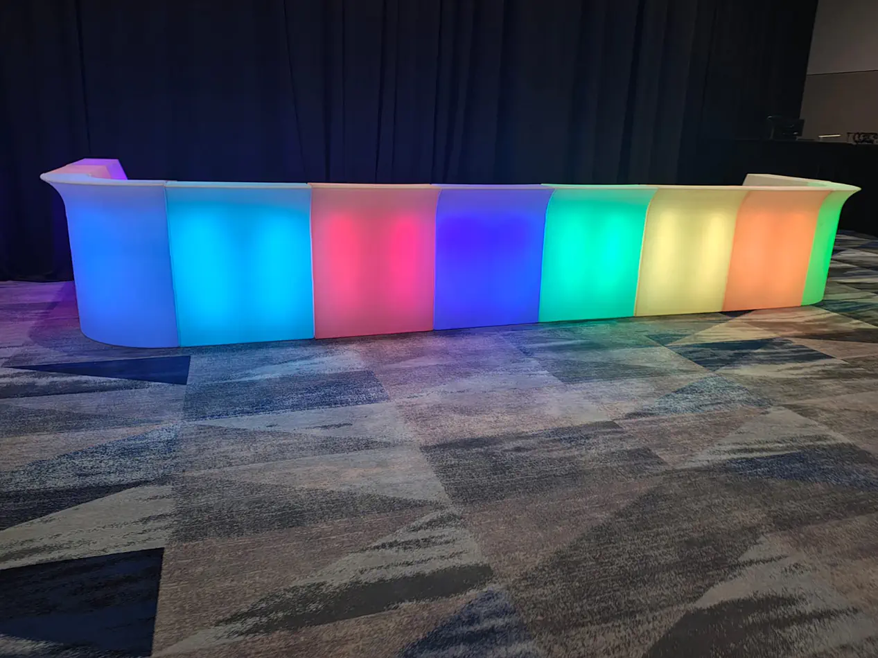 Colour changing illuminated glow bar setup with multicoloured LED panels for a corporate event venue