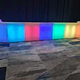 Colour changing illuminated glow bar setup with multicoloured LED panels for a corporate event venue
