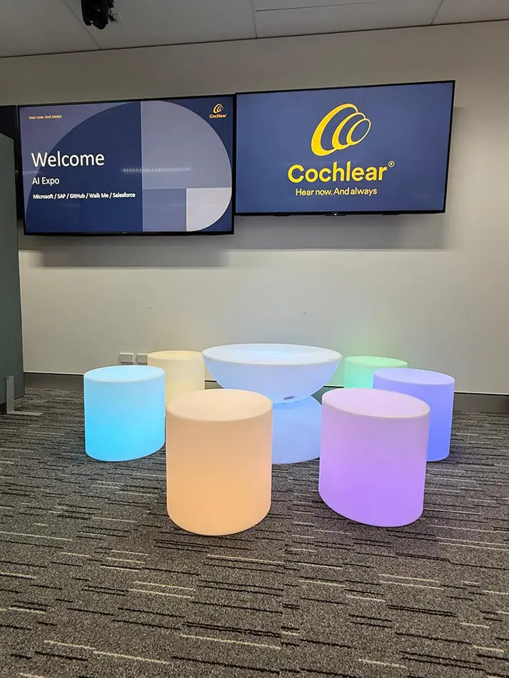 Colour changing glow cylinder seats and illuminated cocktail table setup for a corporate event lounge area