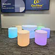 Colour changing glow cylinder seats and illuminated cocktail table setup for a corporate event lounge area