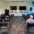 A group of people in conference chairs in a conference room.