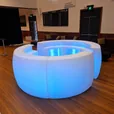 Curved LED glow bar counter glowing white at a function