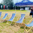 A group of blue and white deck chairs under a tent.