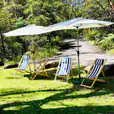 A group of lawn chairs with umbrellas on a grassy path