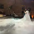 A bride and groom standing on a cloud in a room, enhanced with the mystical ambiance created by a dry ice machine.