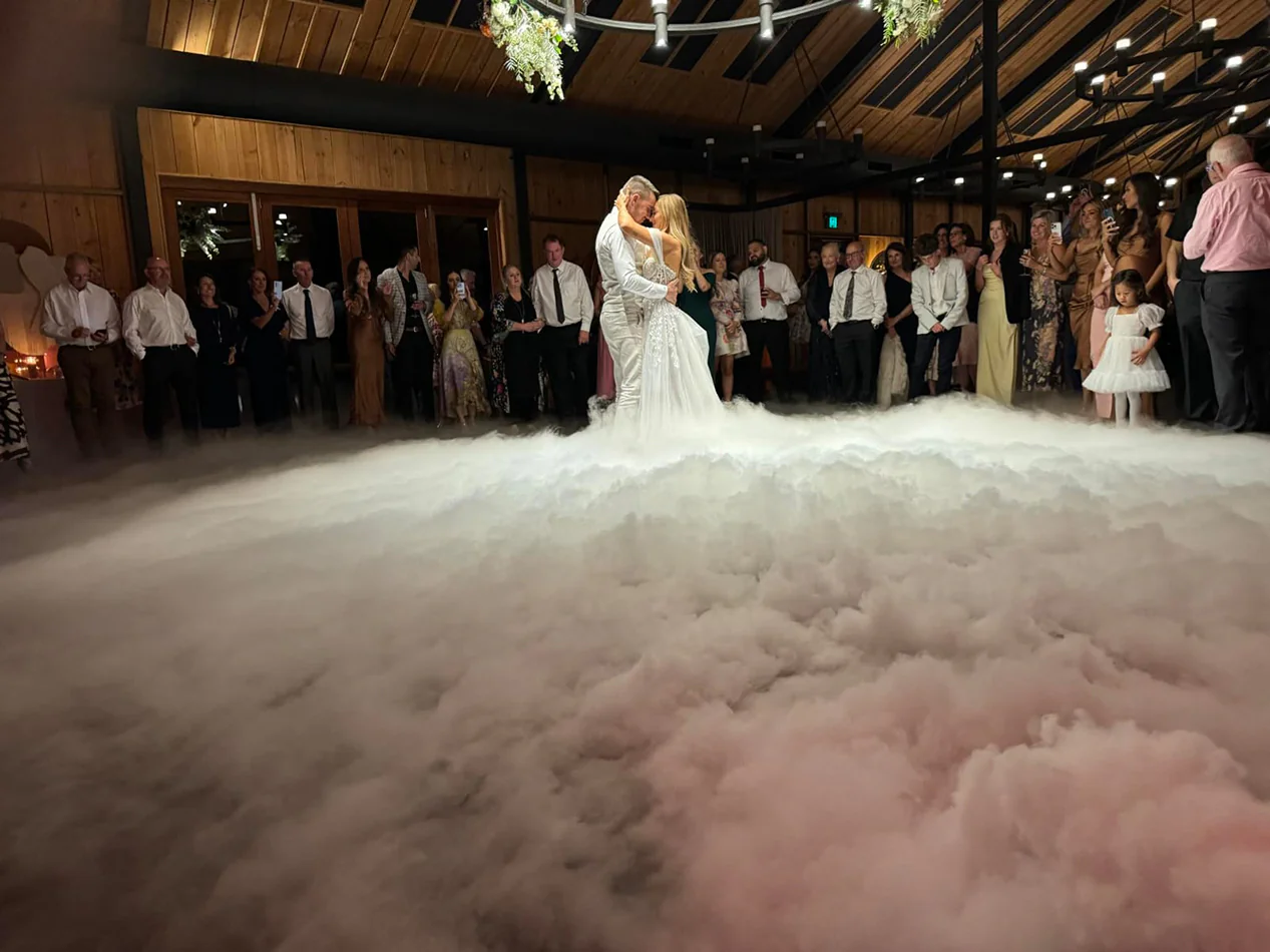 A dance floor covered in dry ice at a wedding