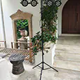 Portable event lighting stand with multiple LED stage lights set up outdoors near a patio area with plants, stone flooring and decorative mirror