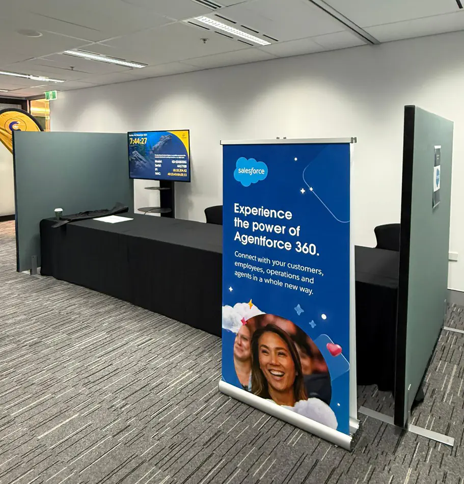Event partition walls forming a registration desk area with branded signage, display screen, and counter setup inside a conference or exhibition space