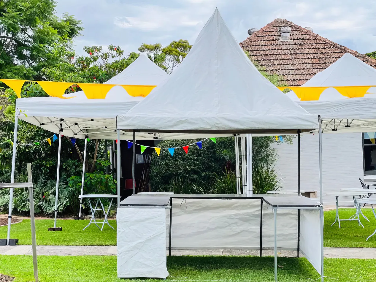 A white tent, part of a fete stall, set up in a grassy area.
