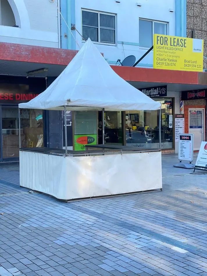 A white tent with a sign on it, available for Fete Stall/Tent Hire.