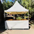 Fete Stall Hire: A white tent with a wooden table and chairs (including setup).