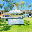 A fete stall/tent hire (including setup) in a grassy area.