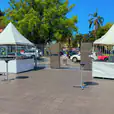 A white fete stall set up in a parking lot.