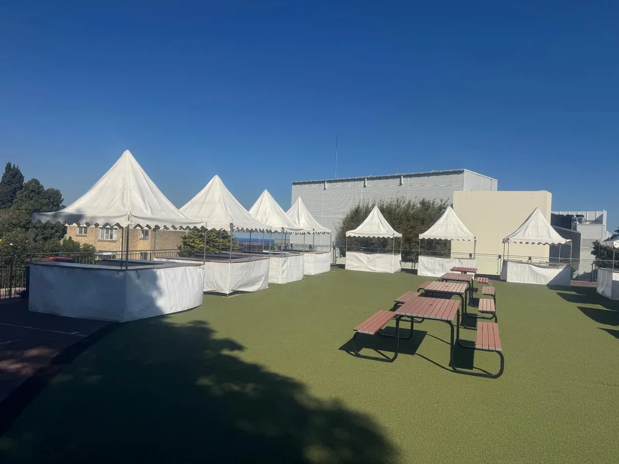 White fete stalls set up in a row for an outdoor community event