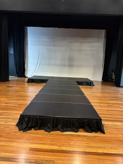Front view of a black stage with a long runway