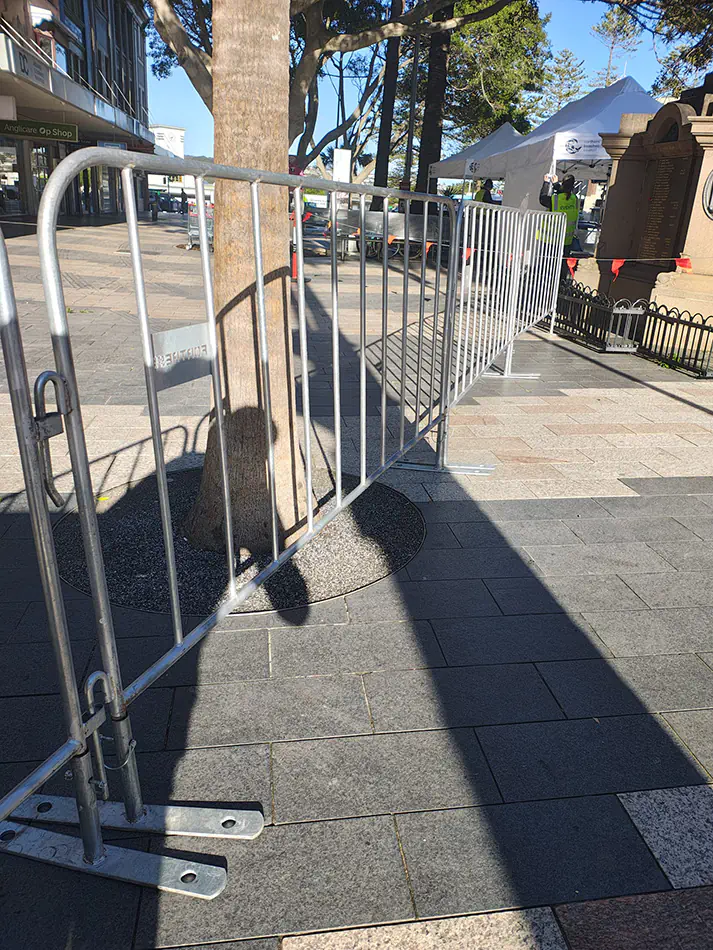 Galvanised crowd control barriers positioned along a public walkway for outdoor event crowd management and access control