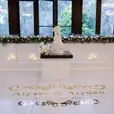 A glamorous wedding reception with a glossy bridal table hire, adorned with a beautifully crafted cake and elegant candles placed delicately on the floor.