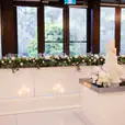 A Gloss Bridal wedding reception with white flowers and candles on a table.
