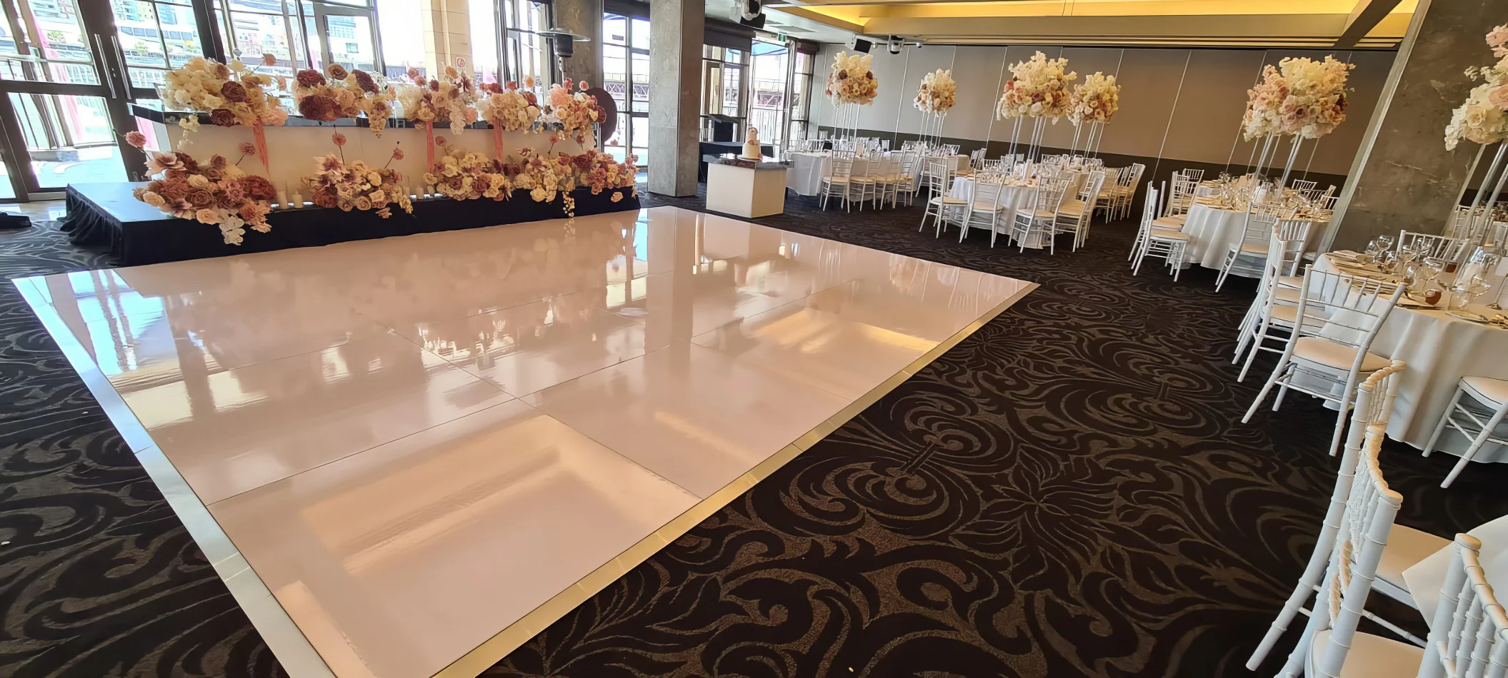 A glossy white dance floor is set up for a bridal wedding.