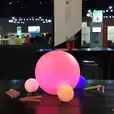 A vibrant ball sitting on a table at a convention, illuminated by a Glow Sphere.