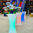 A group of colorful LED bar stools in a warehouse, available for Glow Cocktail Bar Table Hire.