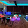 A vibrant Glow Corner with colorful lights and comfortable stools.