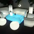 A living room with a white sofa, chairs, and a coffee table available for Glow Couch Hire.