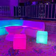 A colorful Glow Cube Hire table and chairs in a room.