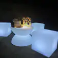 Three large white cubes sitting on a coffee table at night, emitting a gentle glow.