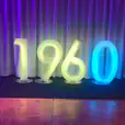 The number 70 is glowing on a stage in front of a curtain.