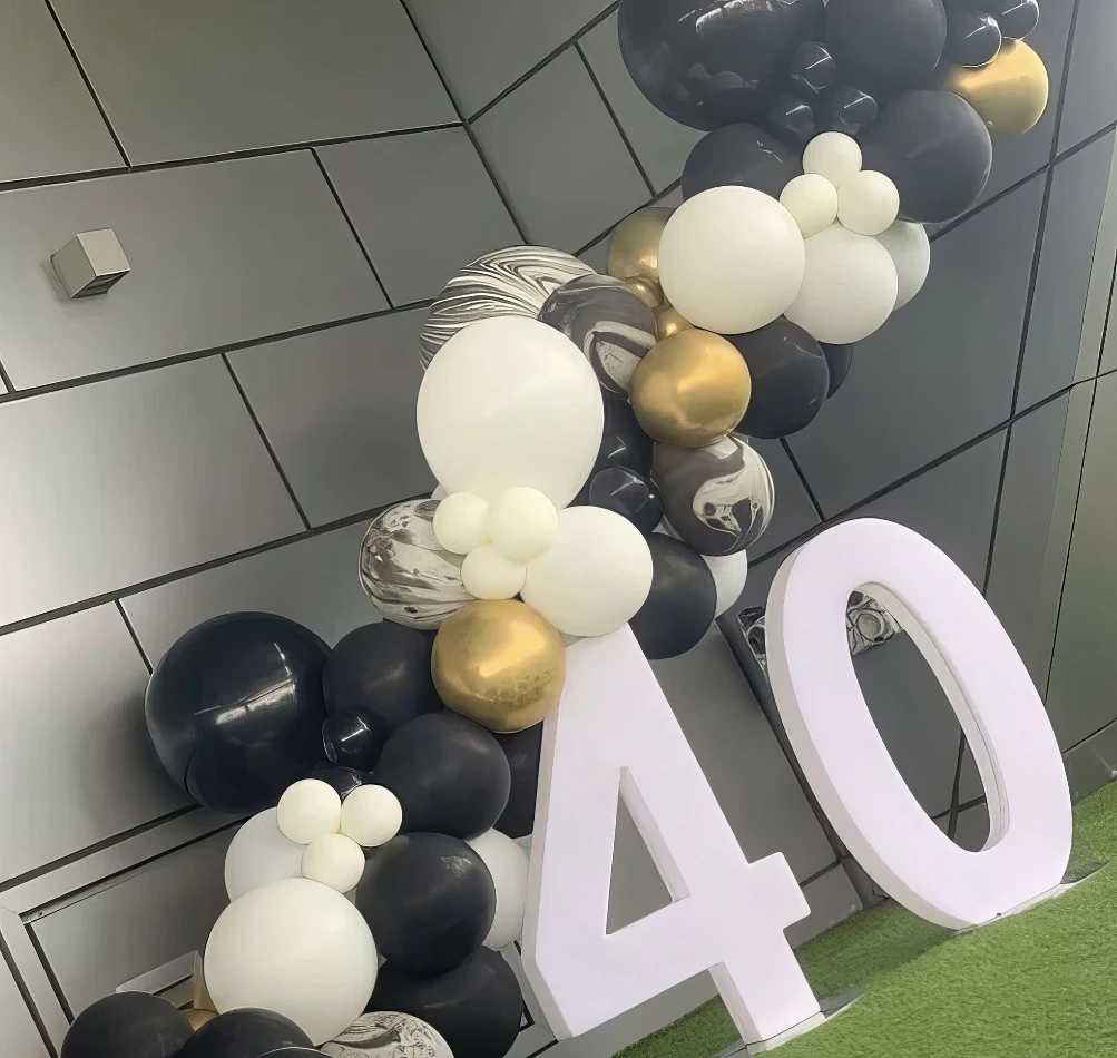 A black and gold balloon arch with a number 40 on it, available for Glow Numbers Hire.