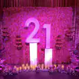 A pink backdrop with the number 21 on it, available for Glow Pillar Hire.