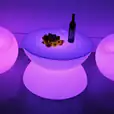 A purple LED table with a bottle of wine.