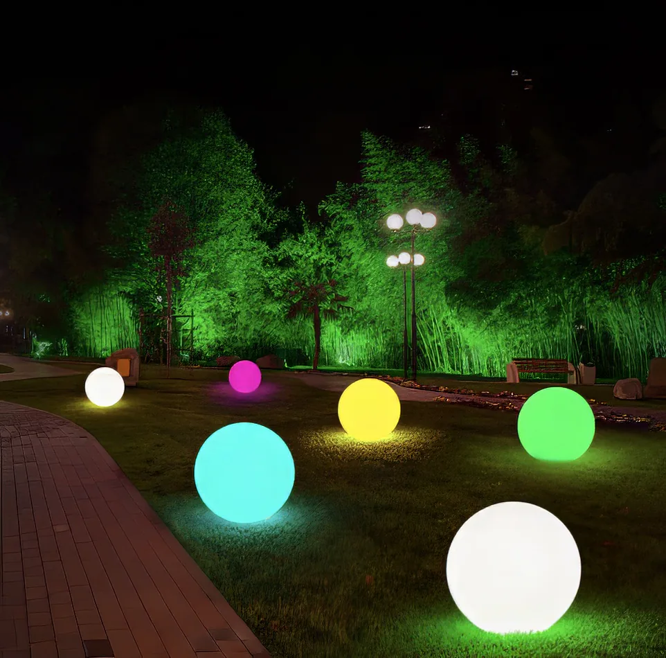 A group of vibrant ball lights in a park at night, available for Glow Sphere Hire.