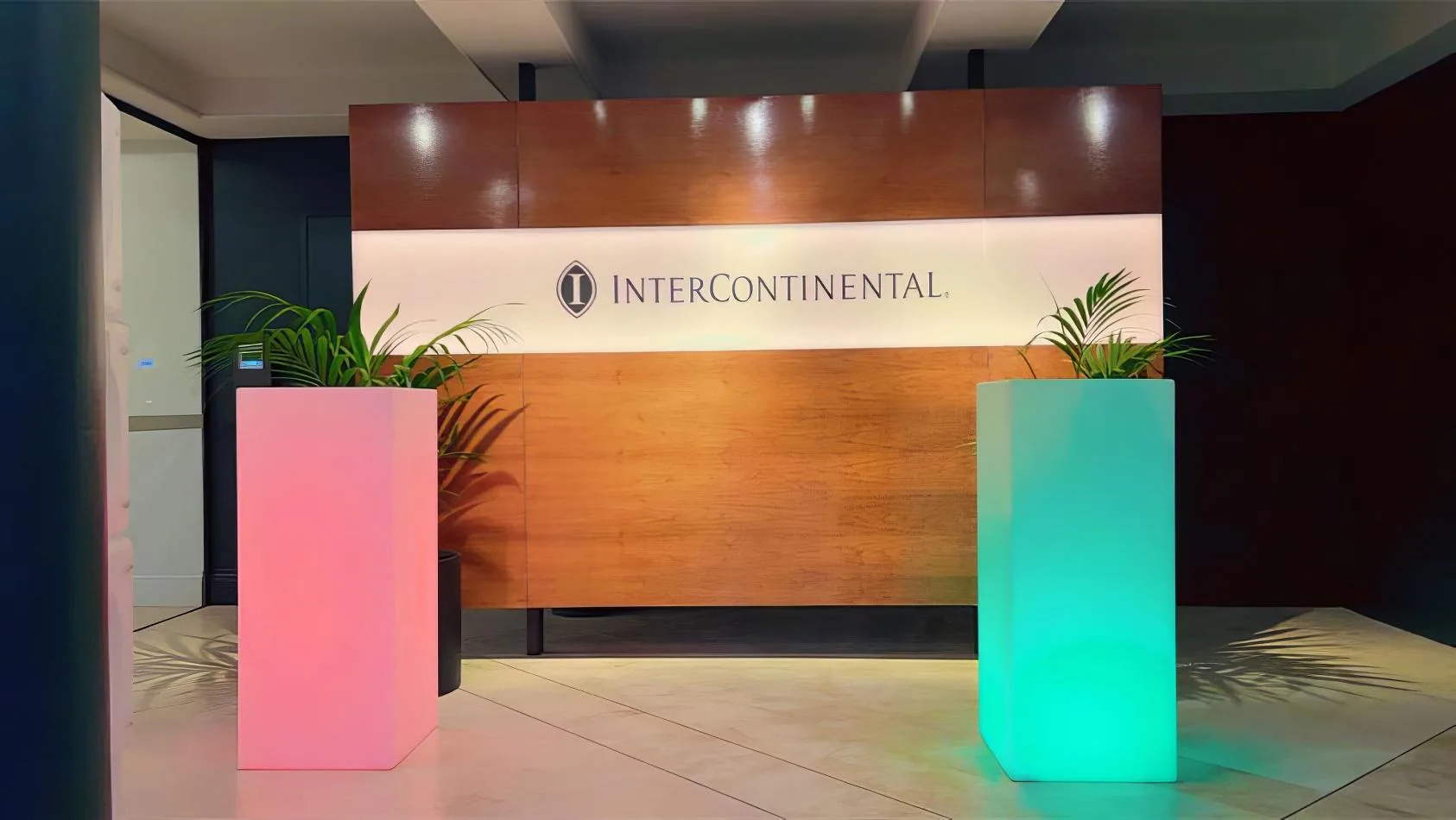 The entrance to a building with a colorful sign in front of it, featuring a vibrant Glow Square.