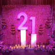 A pink backdrop with the number 21 on it for hire.