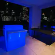 A glowing blue lit table with a stunning view of the city.