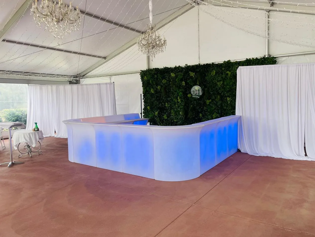 A glowing bar set up in a tent with blue lights.