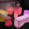 Twisted Cube - a set of colorful lighted furniture in a dark room.