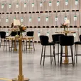 Gold Atlas bar tables with black velvet bar stools at an indoor event