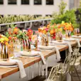 A table set with gold flowers on a rooftop.