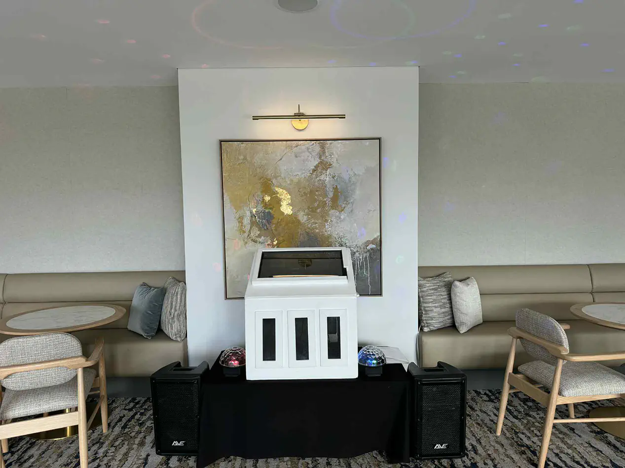 Karaoke jukebox and speaker system setup inside a modern lounge and function room with booth seating and ambient lighting