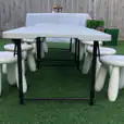 Kids Table Hire: A white table and stools set up in a grassy area.