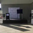 A lectern hire stage set up in front of a large warehouse.