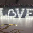 A large light up white letter 'love' on a white floor.