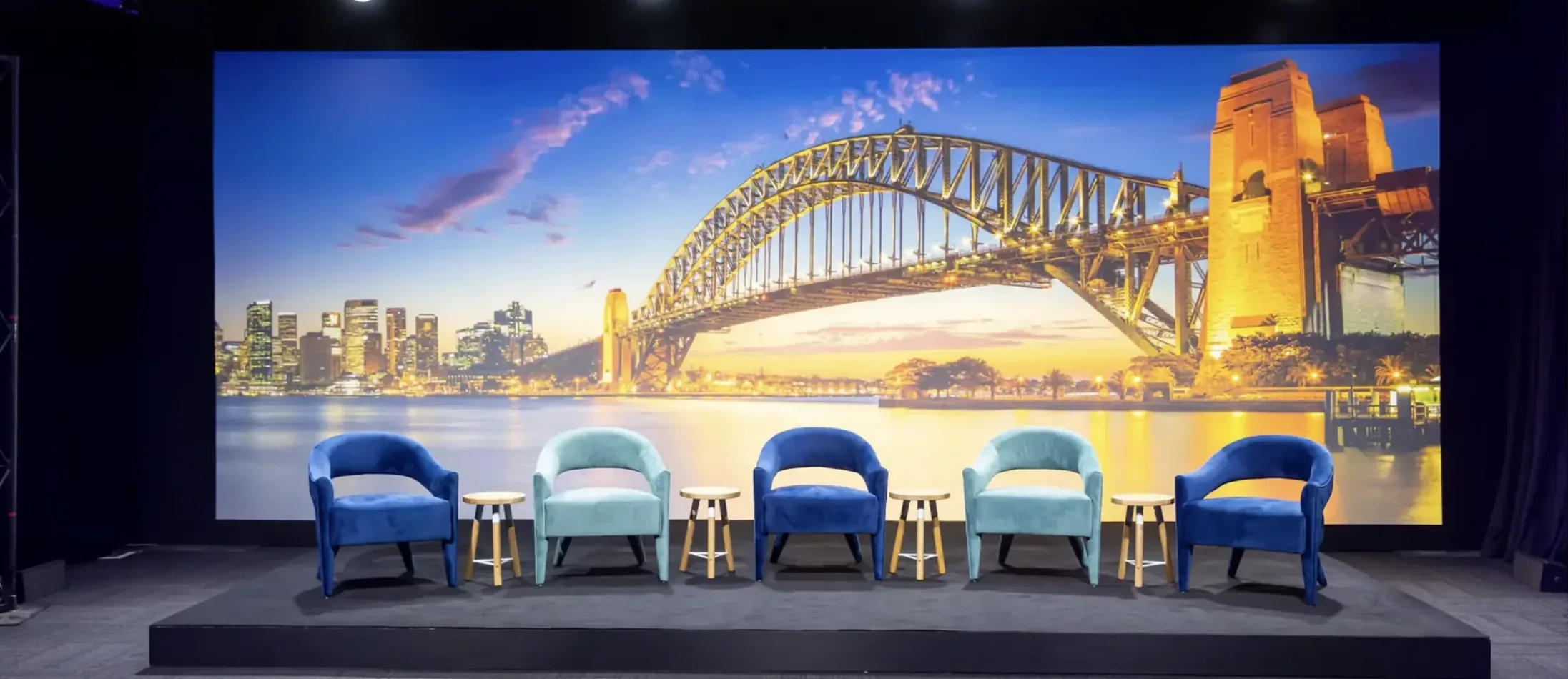 Navy blue and teal velvet Lola arm chairs arranged in an event lounge