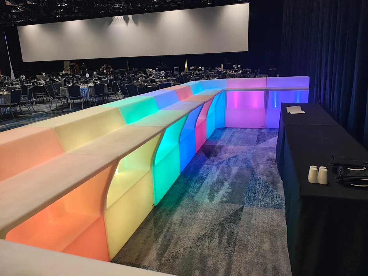 Modular LED glow bar with illuminated colour changing panels installed inside a large corporate gala venue
